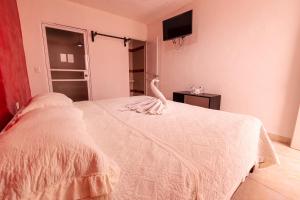 a bedroom with a white bed with a towel on it at Hotel Bello Caribe Express in Cozumel +42 photos