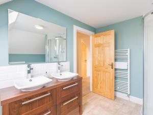 een badkamer met 2 wastafels en een grote spiegel bij Chauffeur's Cottage with Hot Tub in Cray
