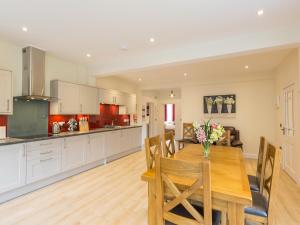 a kitchen and dining room with a wooden table and chairs at Chauffeur's Cottage with Hot Tub in Cray