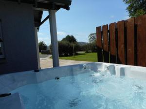 une baignoire jacuzzi dans l'arrière-cour d'une maison dans l'établissement Chauffeur's Cottage with Hot Tub, à Cray