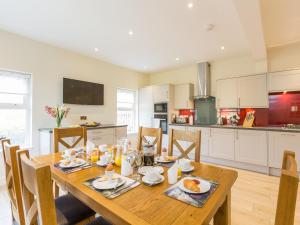 a kitchen and dining room with a wooden table and chairs at Chauffeur's Cottage with Hot Tub in Cray +25 photos