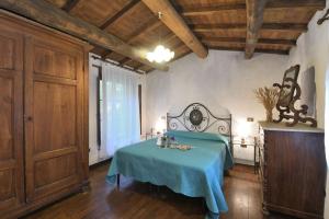 a bedroom with a bed with a blue blanket at La Casetta in Coreglia Antelminelli