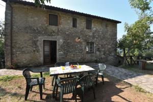 a table and chairs in front of a stone building at Casa Manu in Coreglia Antelminelli