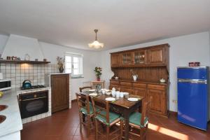 a kitchen with a table and a blue refrigerator at Casa Manu in Coreglia Antelminelli