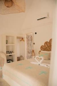 La Isla Bonita Gili Air في غيلي آير: غرفة نوم مع سرير أبيض كبير في غرفة