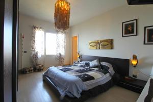 a bedroom with a large bed and a chandelier at Vista Mare in Montignoso