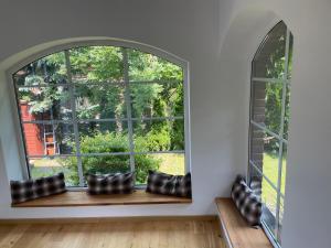 an arched window in a living room with cushions on a window sill at Apartament z ogrodem in Starogard Gdański