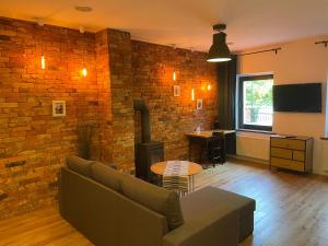 - un salon avec un canapé et un mur en briques dans l'établissement Apartament z ogrodem, à Starogard Gdański