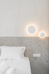 - une chambre avec un lit blanc et deux lumières sur le mur dans l'établissement Kampus Luxury Villas, à Tríkala