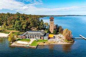 an island with a clock tower in the middle of the water at Pet-Friendly Loft Vacation Rental with Fire Pit! in Bemus Point