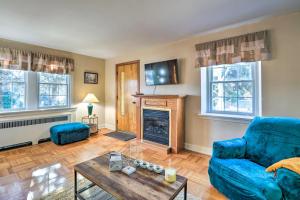 a living room with a blue couch and a fireplace at Yeadon Townhome with Porch, 7 Mi to Center City in Drexel Hill