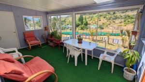 Habitación con mesa, sillas y ventana grande. en Cabaña el Coiron, en Cochrane