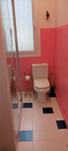 a bathroom with a toilet and red walls and a window at Apartamento Guggenheim cèntrico y confortable in Bilbao