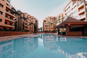een zwembad voor sommige gebouwen bij Luxueux appartement Marrakech au cœur de l hivernage in Marrakesh