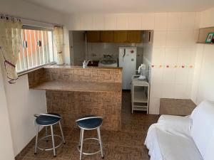 una pequeña cocina con 2 taburetes y una encimera en Casa de hospedagem no Mirante de Piratininga en Niterói