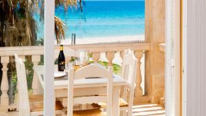 uma mesa branca e cadeiras numa varanda com vista para a praia em SUN OF THE BAY em Alcudia