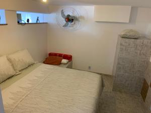 a small bedroom with a bed and a fan at Casa de hospedagem no Mirante de Piratininga in Niterói