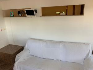 um quarto com um sofá branco e uma mesa em Casa de hospedagem no Mirante de Piratininga em Niterói