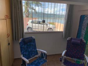 duas cadeiras num quarto com um carro fora da janela em Casa de hospedagem no Mirante de Piratininga em Niterói