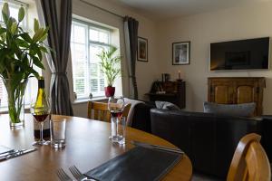 einen Esstisch mit Weingläsern und ein Sofa in der Unterkunft The Royal Oak Exmoor in Winsford