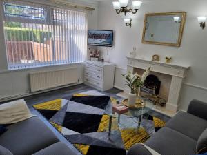 a living room with a table and a fireplace at Modern 2-Bed Home - Private Garden Parking & WiFi in Leeds