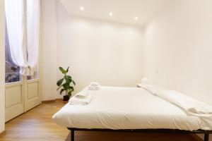 Top Accommodations in the Heart of Milano! في ميلانو: سرير أبيض في غرفة بها نافذة