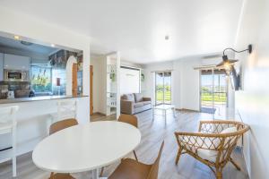 eine Küche und ein Wohnzimmer mit einem weißen Tisch und Stühlen in der Unterkunft Pontalaia Apartamentos Turísticos in Sagres