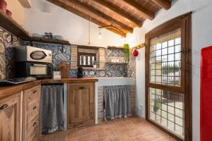 a kitchen with wooden cabinets and a microwave at Casa di Campagna in Colle Val D'Elsa