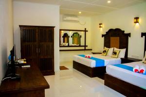 a hotel room with two beds and a television at Manike Lodge Habarana in Habarana