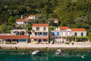 a group of houses and a boat in the water at Spacious apartment Lucia in Prožura