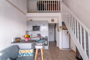 cocina con armarios blancos y sofá azul en Chabine - avec terrasse, en Martigues