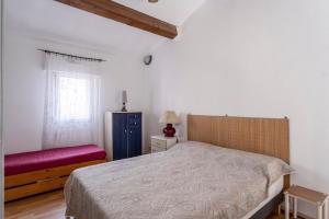1 dormitorio con cama, banco rojo y ventana en Chabine - avec terrasse, en Martigues