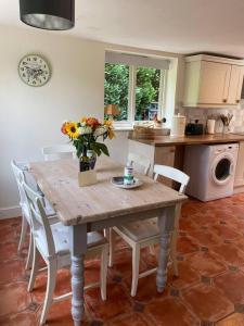 a kitchen with a wooden table with a vase of flowers on it at Stable Cottage Peaceful Stunning Retreat near Bath in Upavon