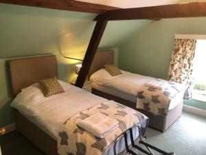 a bedroom with two beds in a room with a window at Stable Cottage Peaceful Stunning Retreat near Bath in Upavon