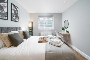 a bedroom with a large white bed with a desk at Westfield Apartment 2 Bedroom near Notting Hill in London