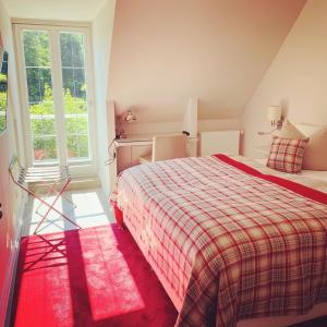 a bedroom with a bed and a large window at Fürst Bismarck Mühle in Aumühle