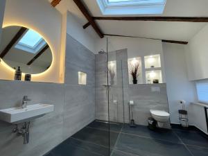 uma casa de banho com um lavatório, um WC e um espelho. em GLEIS 13 - THE LOFT im ehemaligen Lokschuppen em Buckeburgo