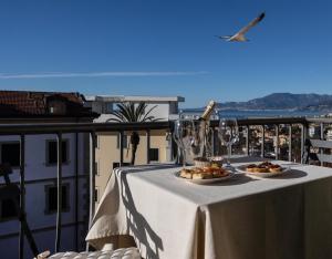 a table with two plates of food on a balcony at Dormiusa in Bordighera
