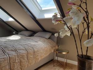 a bedroom with a bed and a vase with flowers at 16 Personen Harzhaus für Gruppen in Clausthal-Zellerfeld in Clausthal-Zellerfeld