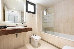 bagno con servizi igienici, lavandino e specchio di ChicStays Apartment Vila Olímpica a Barcellona