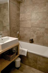 a bathroom with a sink and a bath tub and a sink at Klochette - Charme et Famille, Appartement 5 étoiles dans Chalet Récent à Villard-Reculas in Villard-Reculas