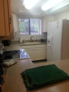 a kitchen with a white refrigerator and a sink at Cozy Flagstaff Home in Cool Pines - Country Club in Flagstaff
