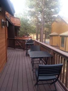 een terras met twee stoelen en een tafel en een grill bij Cozy Flagstaff Home in Cool Pines - Country Club in Flagstaff