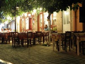 a woman sitting at a table in a restaurant at Megim Hotel in Palaiochora