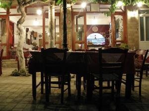 a dining table and chairs in a restaurant at Megim Hotel in Palaiochora