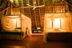 Hotel El Copal في مازونتي: سريرين في غرفة مع مروحة سقف