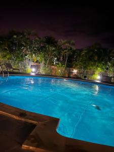 Azuri Lodge Duplex Marina في سانت فرانسوا: حمام سباحة أزرق كبير في الليل