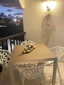 einen Tisch mit einem Tablett mit Speisen auf dem Balkon in der Unterkunft Azuri Lodge Duplex Marina in Saint-François