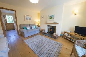 a living room with a couch and a fireplace at Yewdale Cottage Coniston in Coniston