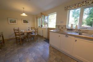 a kitchen with a table and a sink and a table and chairs at Yewdale Cottage Coniston in Coniston
